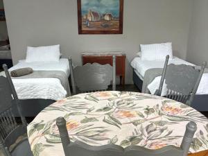 a room with two beds and a table and chairs at Hekpoort Rorymi Guest farm in Hekpoort