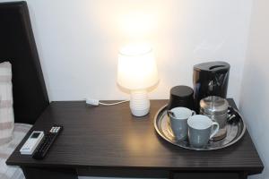 a table with a lamp and coffee cups on it at Sunlit Retreat Private Flatlet with Solar Power Pool Fast WiFi & Secure Parking in Roodepoort