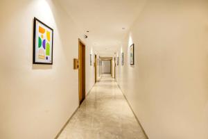 a long hallway with paintings on the walls at Treebo Sairadha in Pune