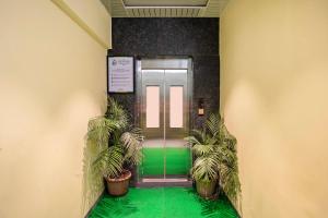 an elevator lobby with green floors and potted plants at Treebo Sairadha in Pune +44 photos