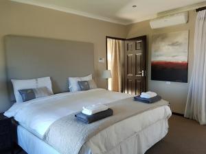 a bedroom with a large bed with towels on it at Seaside Hermanus Guest Room in Hermanus