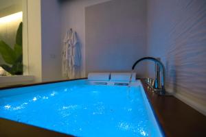 a large blue tub with a faucet in a bathroom at D'AlottoSuite&Rooms in Leonforte