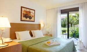 a hotel room with a bed with a tray of food on it at Renaissance Hanioti Resort in Hanioti