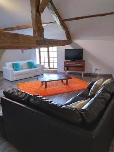 a living room with a leather couch and a coffee table at Maison Belle Vue in Cherval