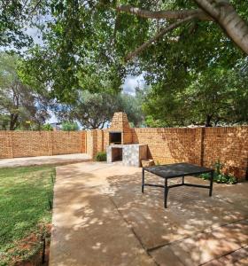 a patio with a table and a brick wall at Flat 1 in Kimberley