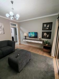 a living room with a couch and a flat screen tv at Flat 1 in Kimberley