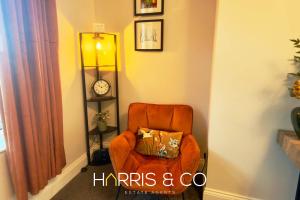 an orange chair with a pillow in a room at Driftwood Bay in Fleetwood