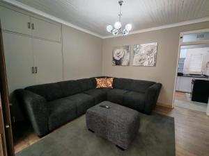 a living room with a black couch and a table at Flat 1 in Kimberley