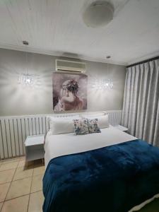 a bedroom with a bed and a painting on the wall at Flat 1 in Kimberley
