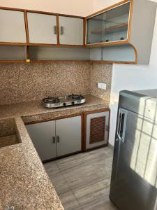 a kitchen with white cabinets and a stainless steel refrigerator at Happy Homes 2BHK Second Floor Panchkula in Panchkula