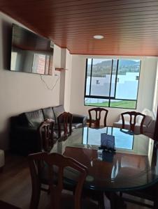 a dining room with a glass table and chairs at Casa punta del este in Paipa