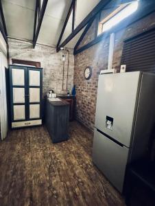 a kitchen with a refrigerator and a brick wall at Revenir in Middelburg +28 photos