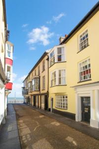 an empty street with buildings and the ocean in the background at 4 Bed in Cromer oc-2117 in Cromer