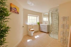 a bathroom with a shower and a toilet and a sink at 4 Bed in Cromer oc-2117 in Cromer +14 photos