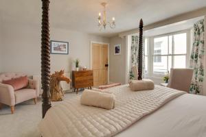 a bedroom with a four poster bed and a chair at 4 Bed in Cromer oc-2117 in Cromer