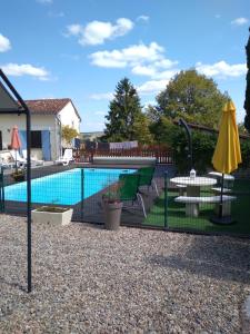 a swimming pool with a table and a yellow umbrella at Maison Belle Vue in Cherval