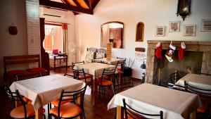 a restaurant with tables and chairs and a fireplace at Cabanas Las Pencas, HOSTERIA in Mina Clavero