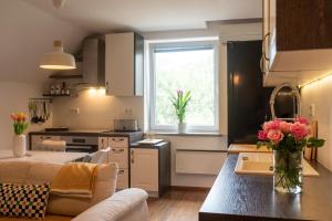 a kitchen and living room with a vase of flowers on a table at Little Oasis Apartment in Zgornje Gorje