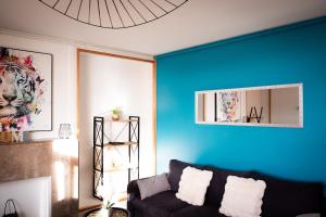a living room with a couch and a blue wall at Have a Cosy, Élégance in Grand-Fort-Philippe