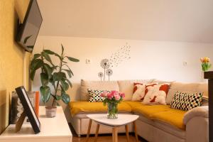 a living room with a couch with pillows and a table at Little Oasis Apartment in Zgornje Gorje
