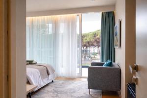 a bedroom with a bed and a window with a chair at Vila Eva in Golem +33 photos