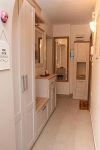 a kitchen with white cabinets and a counter at Little Oasis Apartment in Zgornje Gorje +9 photos