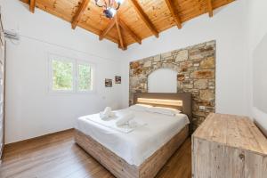 a bedroom with a large bed and a stone wall at Siar The Small Villa by PikHost in Borsh