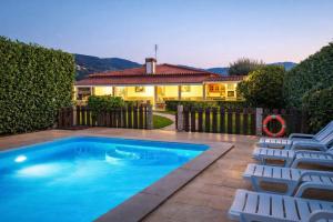 a swimming pool with chairs and a house at Casa Antigo Alambique in Santa Cruz do Lima