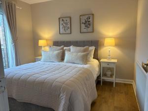 a bedroom with a large bed with two lamps at Kincraig Apartment in Ayr