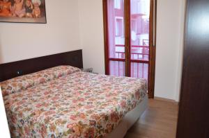 Un dormitorio con una cama con un edredón floral. en Le Sorgenti, en Bormio