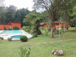 a house with a swimming pool in a yard at Chalé Bosque Encantado Maringá MG in Itatiaia