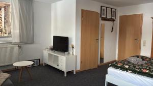 a bedroom with a bed and a tv on a dresser at Souterrain Appartment, eigene Dusche u WC in Detmold