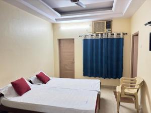 a bedroom with two beds and a blue curtain at SriI Kanya Lodge in Mandapeta