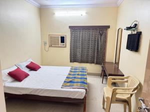 a bedroom with a bed and a desk and a window at SriI Kanya Lodge in Mandapeta