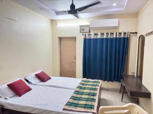 a bedroom with a bed and a blue curtain at SriI Kanya Lodge in Mandapeta