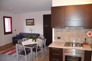 Una cocina y un comedor con una mesa y una cocina y una mesa y sillas. en Le Sorgenti, en Bormio