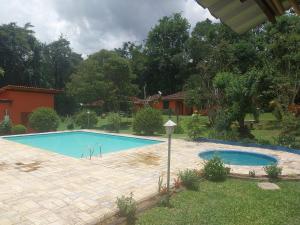 a swimming pool in the yard of a house at Chalé Bosque Encantado Maringá MG in Itatiaia +7 photos