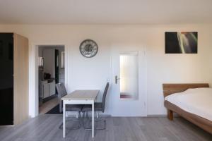 a bedroom with a table and a bed and a clock at Exclusive Home Feeling Flat in Ratingen