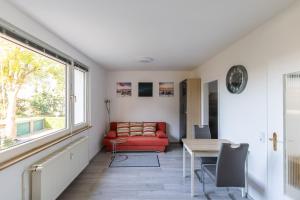 a living room with a red couch and a table at Exclusive Home Feeling Flat in Ratingen