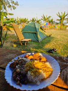 a plate of food on a table with a tent at Dodo's Bamboo Resort in Rāja Māyang