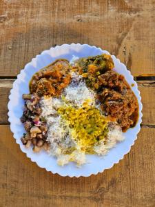 a white plate of food with rice and meat at Dodo's Bamboo Resort in Rāja Māyang