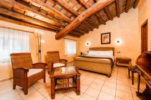 a bedroom with a bed and chairs and a piano at L'Agora Hotel in Bocairent