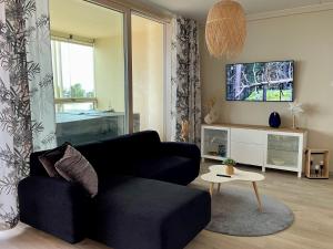 a living room with a black couch and a table at Marina Resort A9 in Kalajoki +3 photos