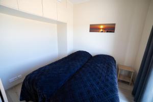 a bedroom with a bed with a blue comforter at Marina Resort A9 in Kalajoki