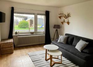 a living room with a couch and a table and a window at Bauernhof-Steffens in Tating