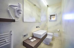 a bathroom with a white toilet and a phone at Hotel Don Ferrante in Bellagio +86 photos
