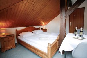 a bedroom with a large bed with a wooden ceiling at Klindworths Gasthof in Sauensiek +11 photos