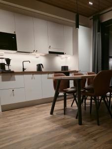 a kitchen with white cabinets and a table and chairs at Metsolinna in Kittilä