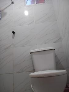 a white bathroom with a toilet and a shower at BELL MAR CHALÉs 03 in Luis Correia