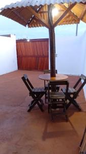 a table and two chairs under an umbrella at BELL MAR CHALÉs 03 in Luis Correia